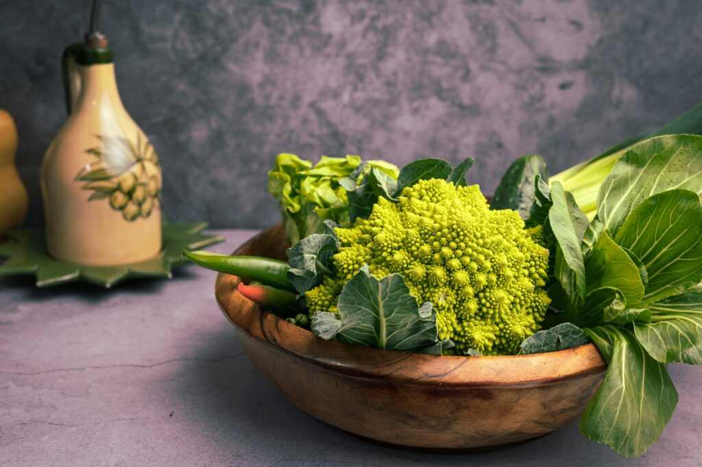 a wooden bowl filled with broccoli and other vegetables