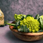 a wooden bowl filled with broccoli and other vegetables