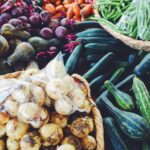 green cucumber and orange fruits on brown woven basket