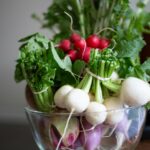 a glass bowl filled with radishes and other vegetables