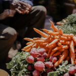 a pile of carrots sitting on top of a pile of lettuce