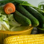 corn and green vegetable on yellow plastic container